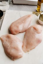 Fresh Chicken Breast, ready to cut on a chopping board