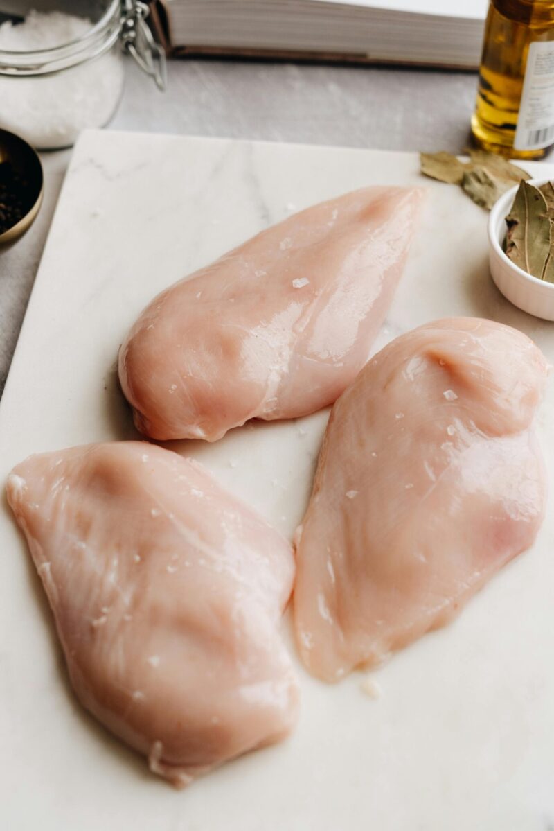 Fresh Chicken Breast, ready to cut on a chopping board